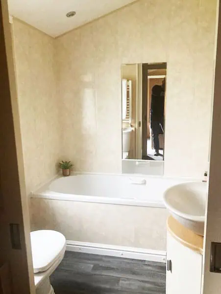 Willerby New Hampshire 8 Light bathroom with a bath tub, sink, and toilet.