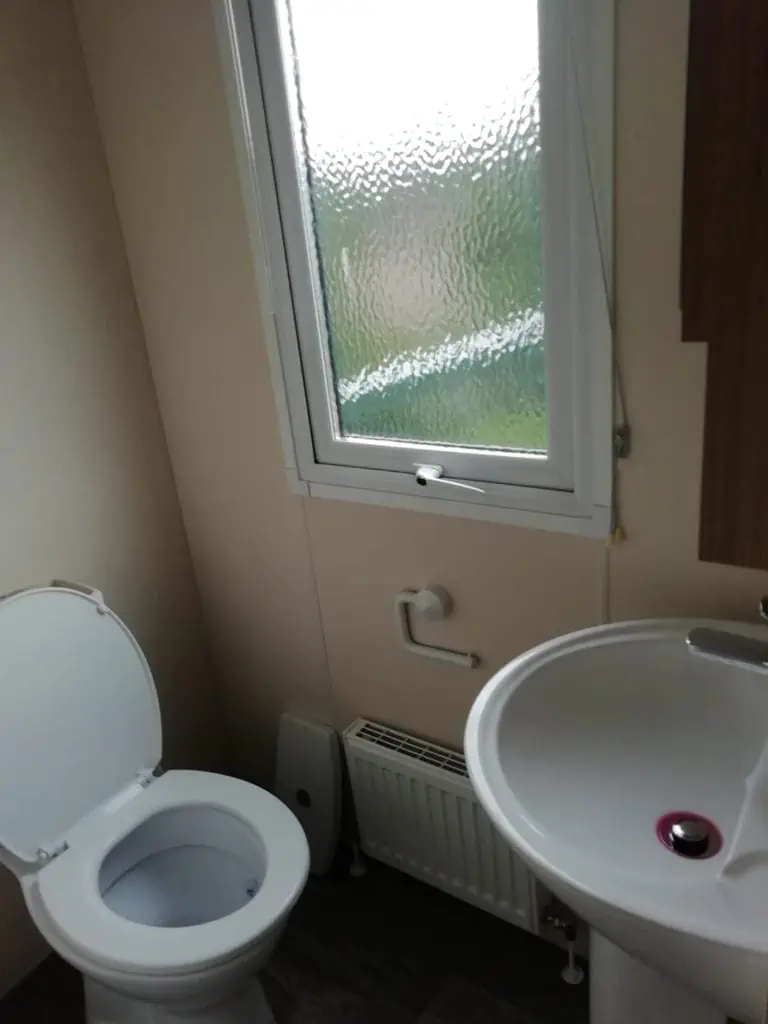 Europa Cypress 3 Europa Cypress bathroom with window, heating, toilet, and sink.