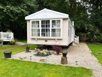 Affordable static home in peaceful holiday park setting with landscaped garden area and decorative window bay