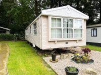 Affordable static home in peaceful holiday park setting with landscaped garden area and decorative window bay