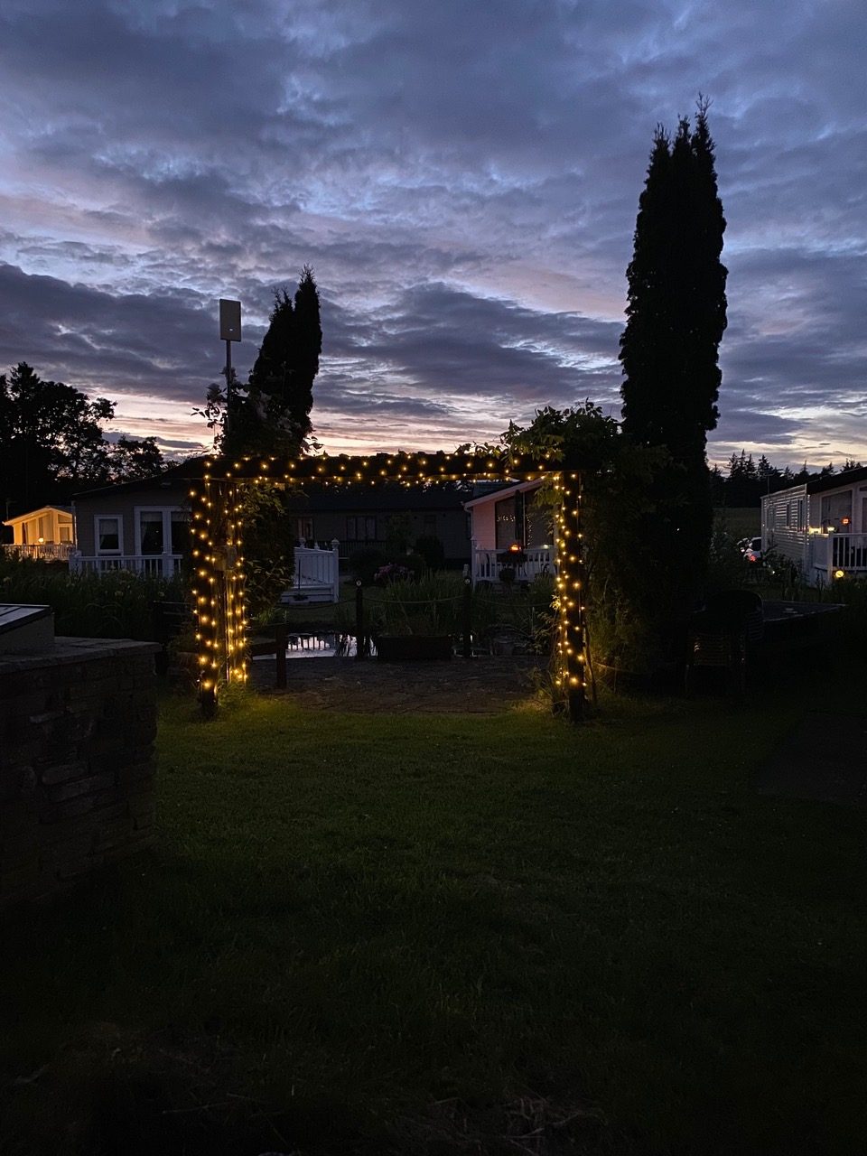 Festive lights on an archway at Heathergate holiday homes during twilight