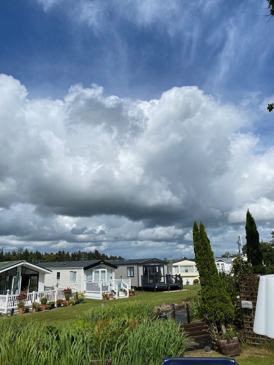 Cloudy sky over Heathergate holiday homes with lush green surroundings